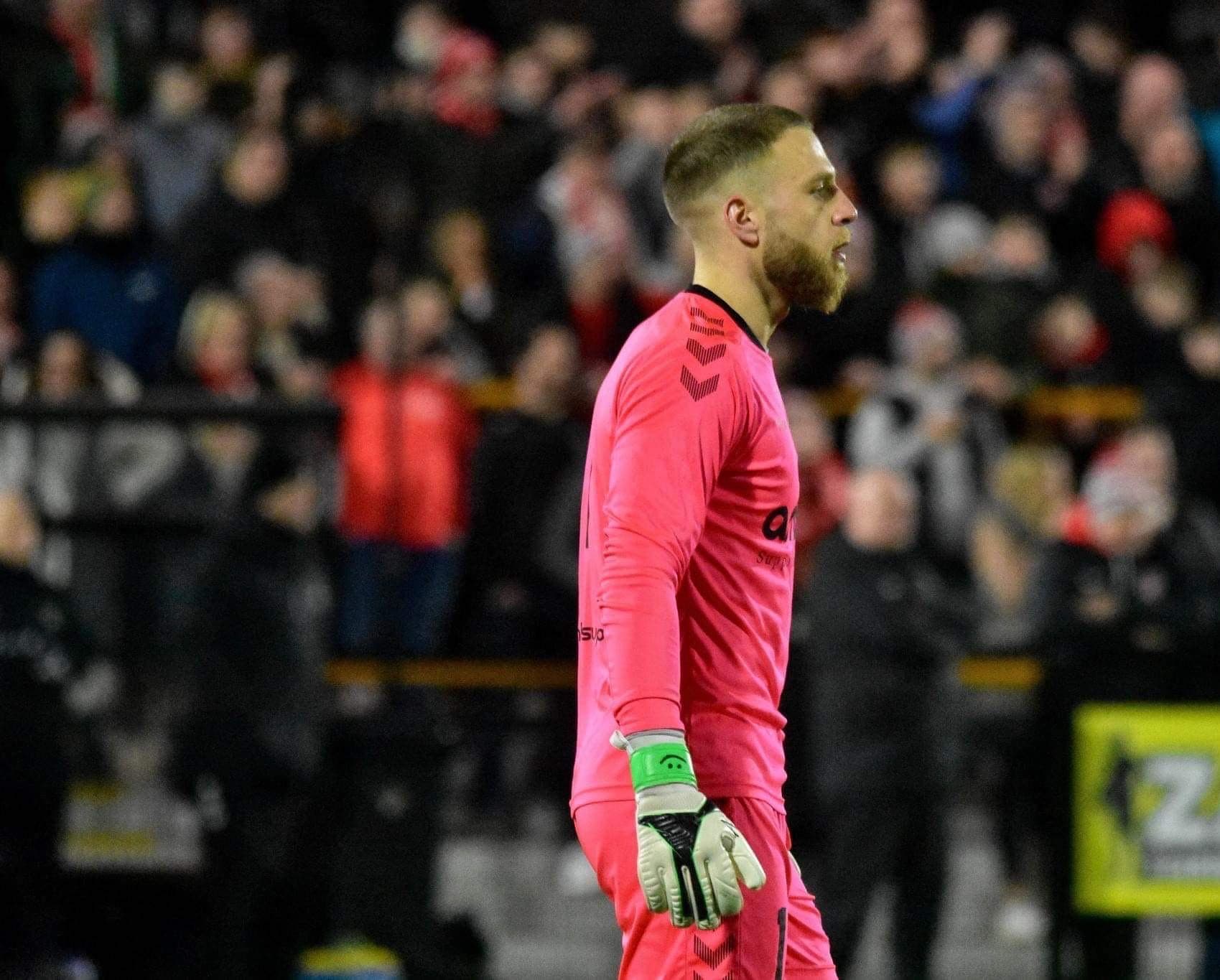 Michael in goal during a professional soccer match, the crowd behind him