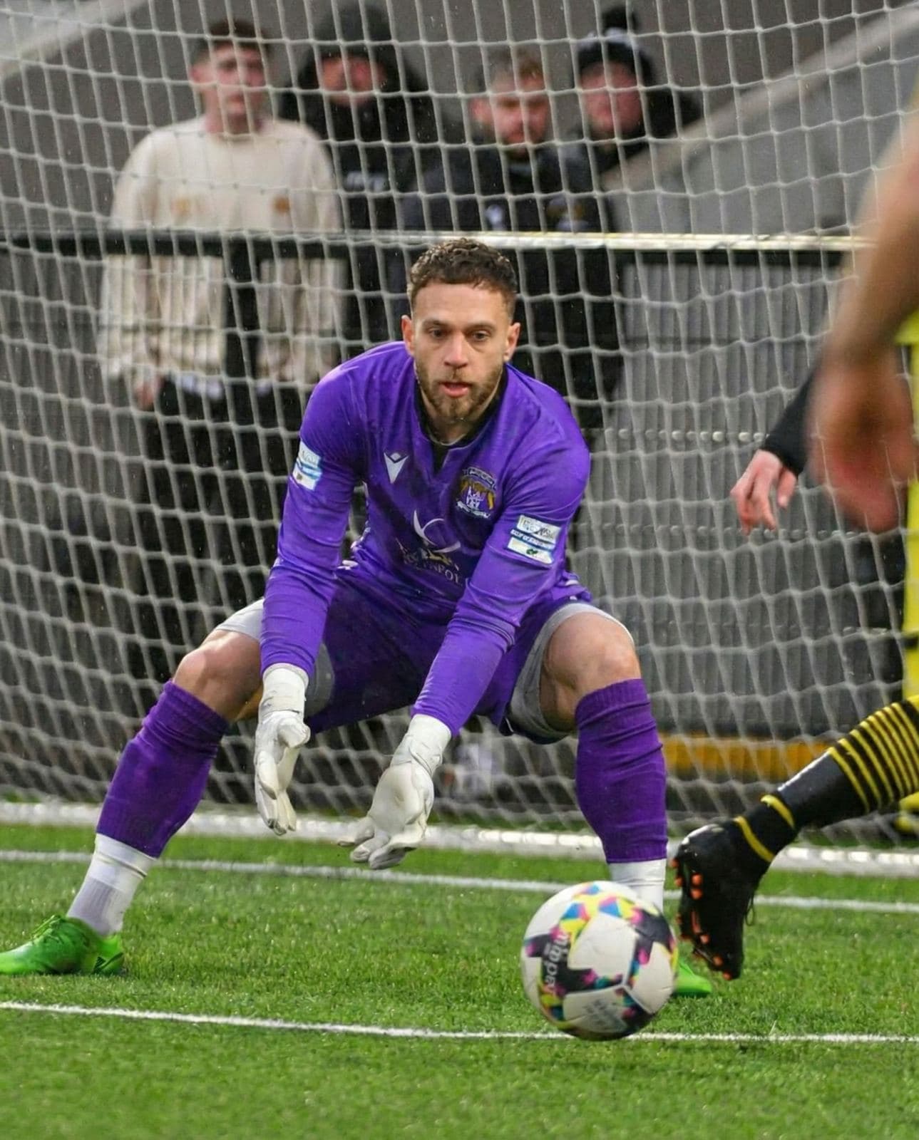 Michael in goal during a professional soccer match, in a purple kit