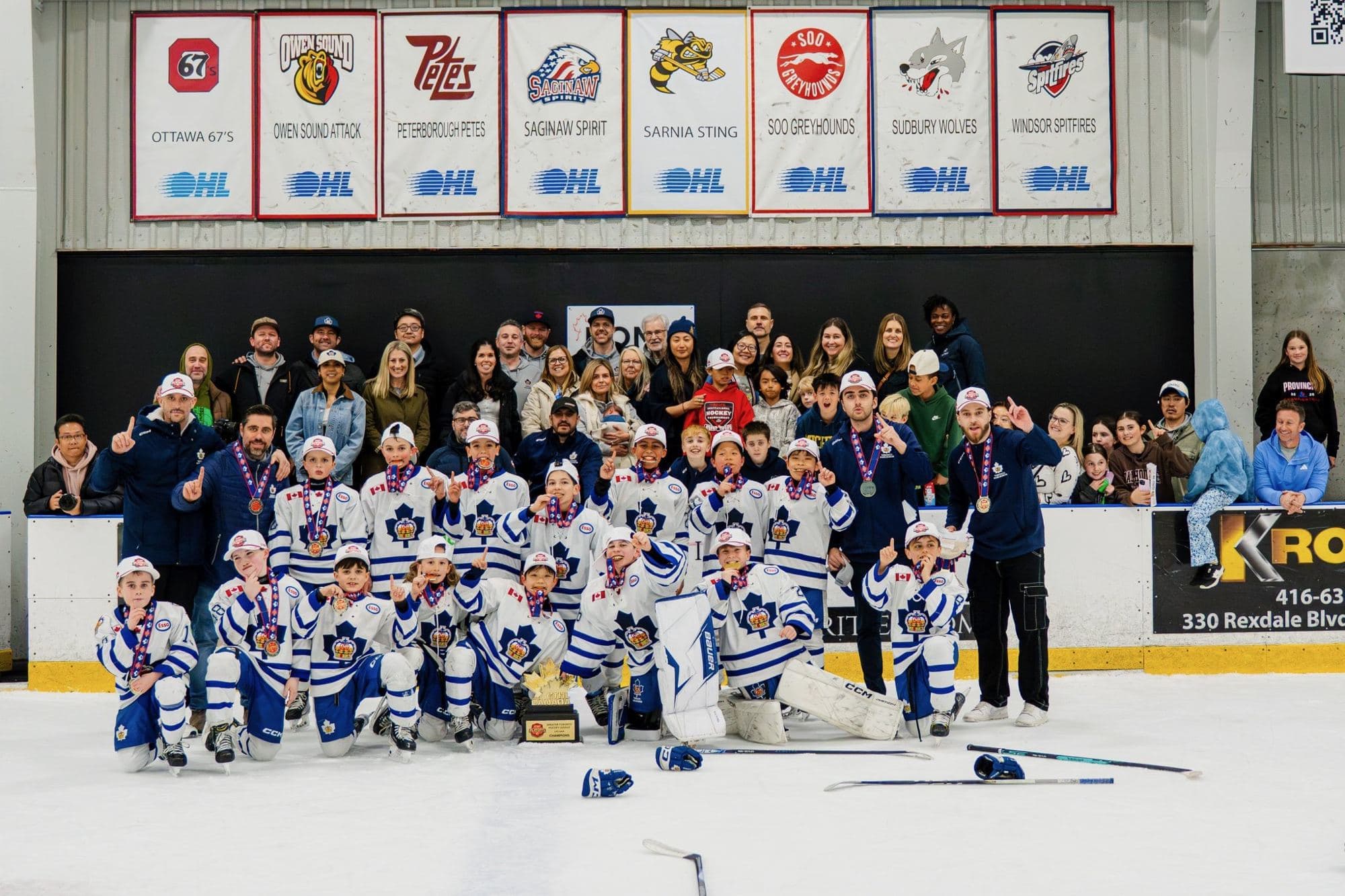 A hockey team and their families celebrating a GTHL championship on the ice